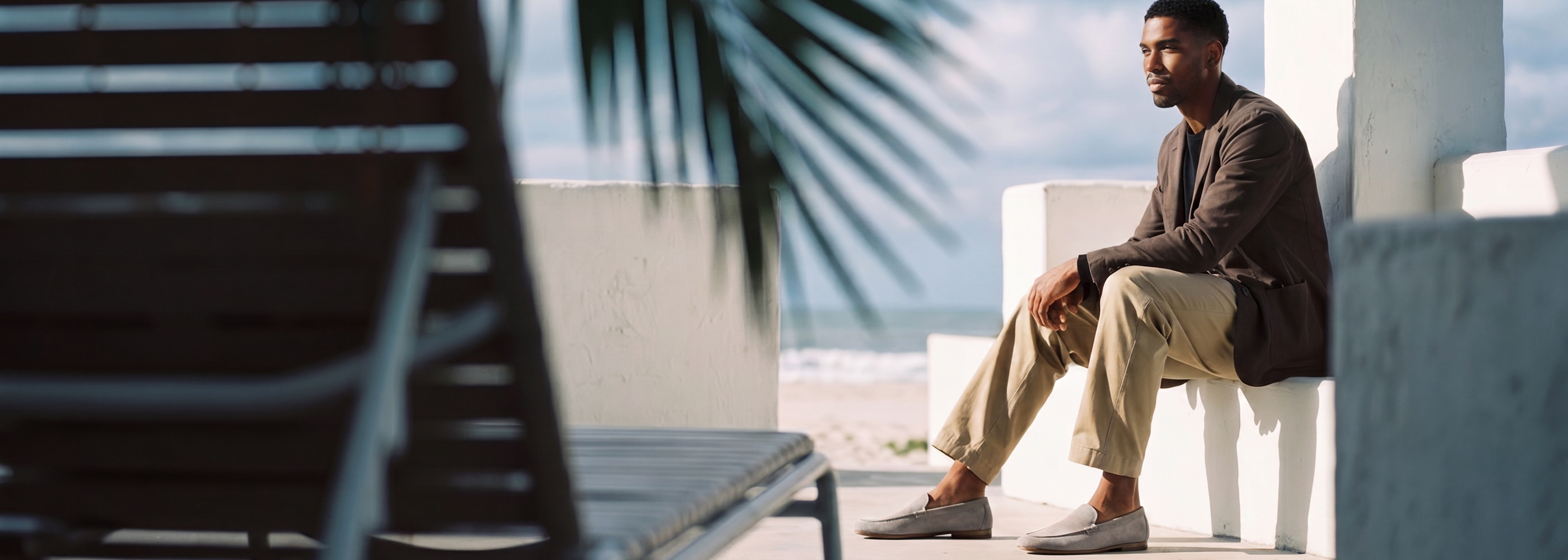 Man sitting by beach wearing Men's European suede leather gray loafers