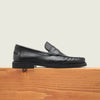 Men's black Italian leather penny loafer dress shoe with black sole.