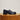 Three-quarter view of Isla Lug Sole shoe showcasing midnight blue polished leather and lug sole on a wooden pedestal with beige background